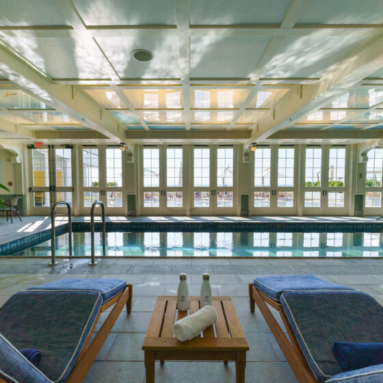 An indoor pool with lounge chairs.