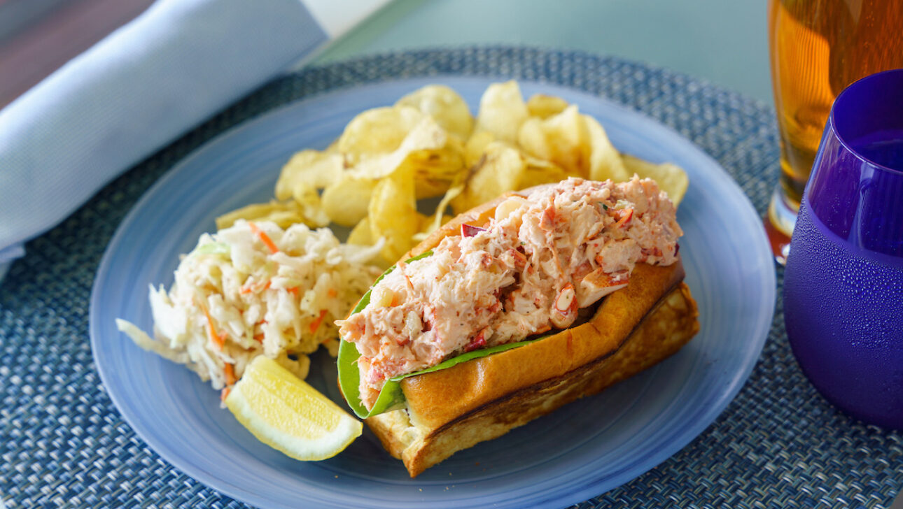 A lobster roll with a side of potato chips and coleslaw at the Verandah Raw Bar.